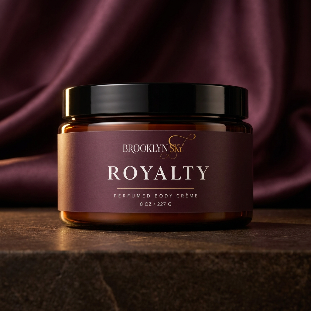 Royalty Body Crème amber jar with a plum label and black lid against a dark background.