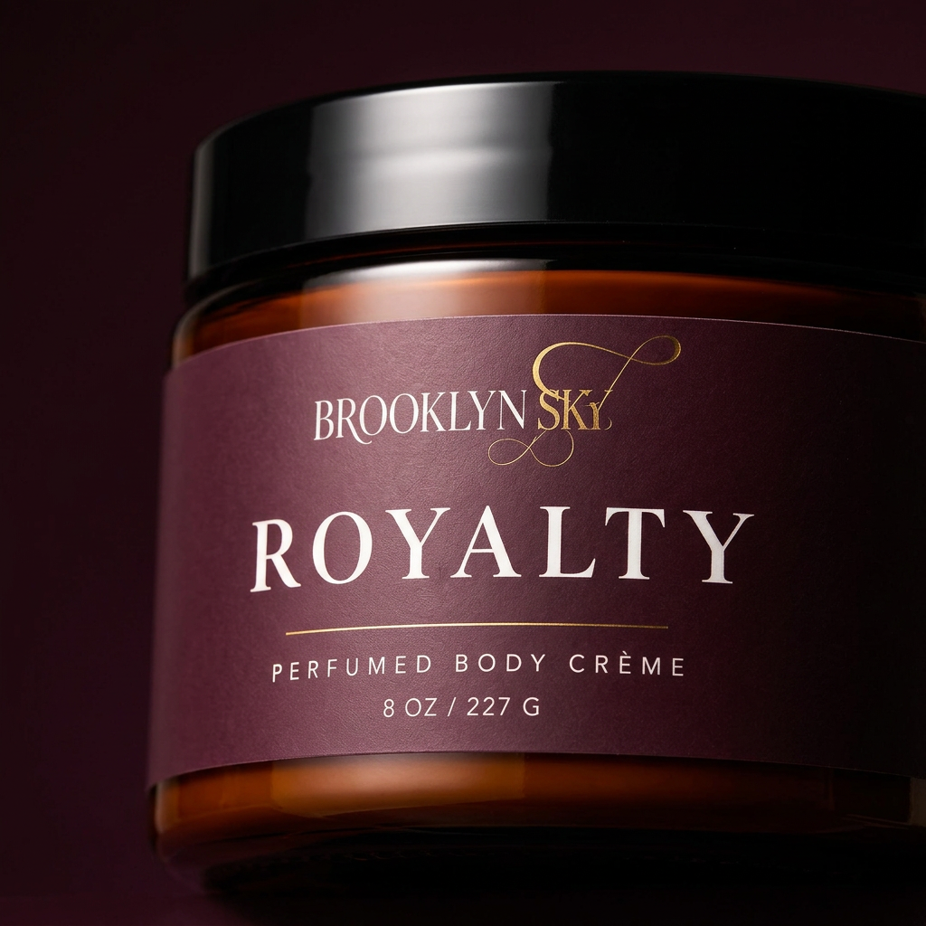 Close-up of Royalty Body Crème plum label, amber jar and glossy black lid.